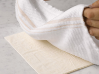 Photograph of chef placing a towel over phyllo dough.