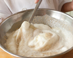 Photograph of eggs being folded into waffle mix.