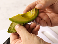 Photograph of peeling skin off of avocado.