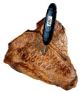 Photograph of a steak with a thermometer in it.